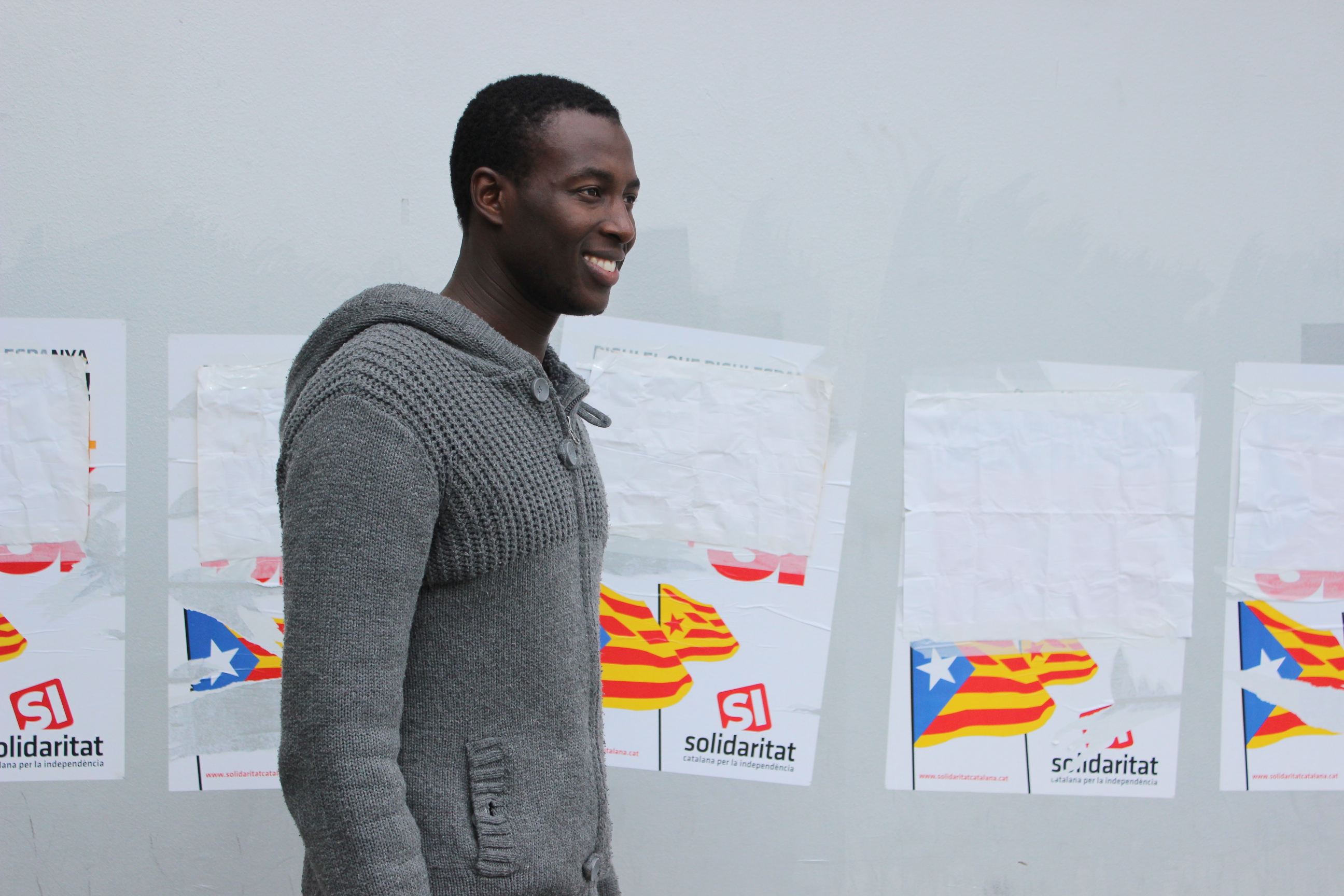 Pape Moussa Ndoye enfrente de unos carteles con la senyera en Terrassa, Catalunya. Foto: Shylean Jarraha